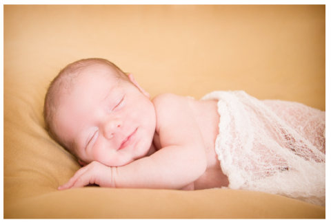 Lay a blanket out as a background for your shot of a newborn.